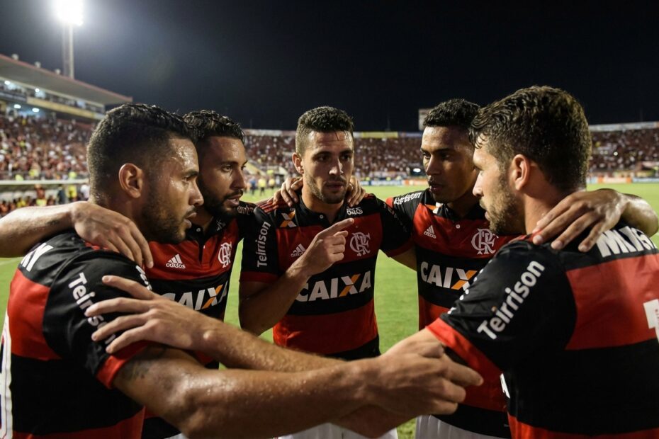 Jogadores do Flamengo em campo com uniformes rubro-negros focados na organização defensiva