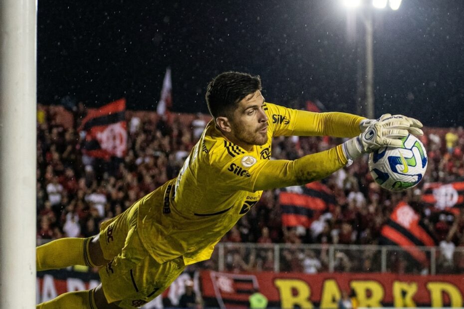 Goleiro Agustín Rossi salta para defender pênalti durante jogo contra o Vitória