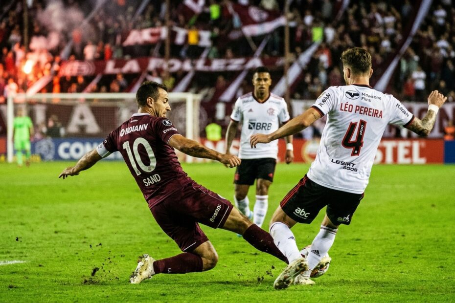 Disputa de bola entre jogadores de Lanús e Flamengo durante jogo da Recopa na Argentina